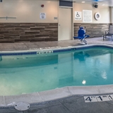 Indoor pool with poolside chairs.