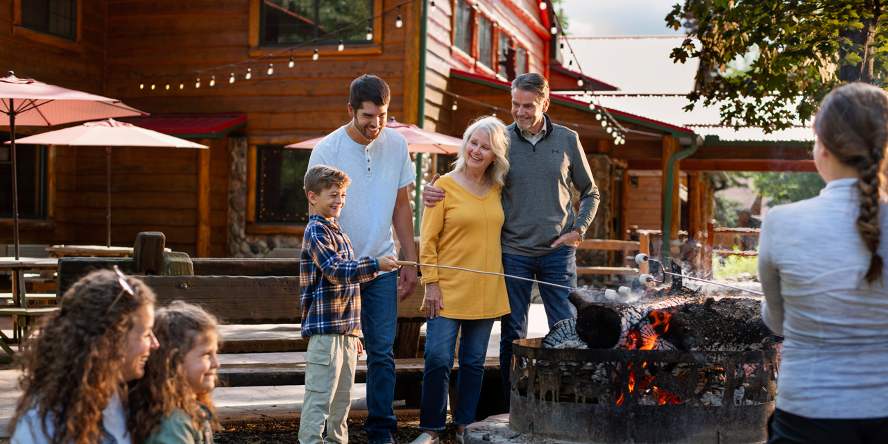 Family making smores by fire.