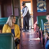 A family relaxing in a train car.