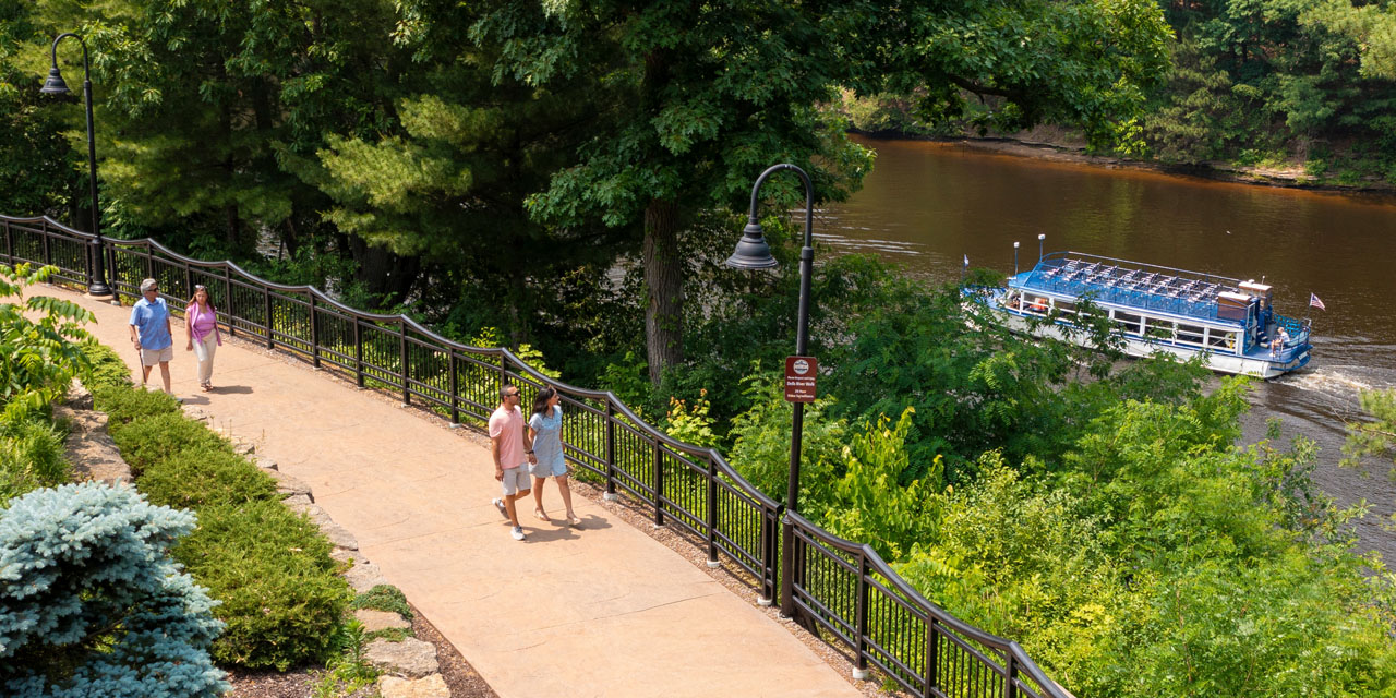 Couples on the River Walk as a tour boat goes by