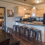 Full kitchen with barstool seating, kitchen table, and chairs.