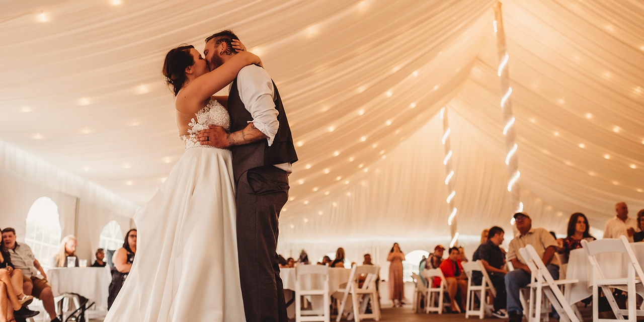 A couple at their wedding with guests.