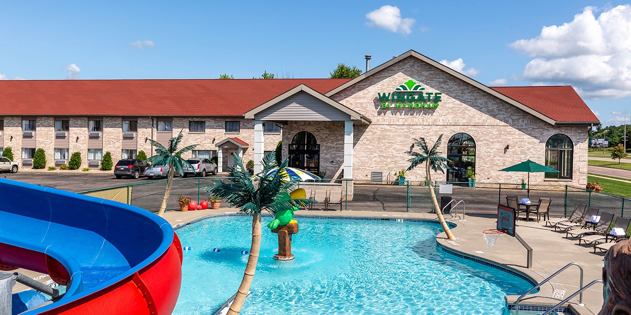 Exterior and pool area with slide and basketball hoop.